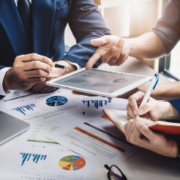 Coworkers analyzing graphs on tablet Coworkers analyzing graphs on tablet